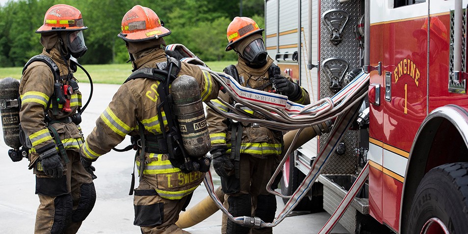 Firefighter students working with fire hoses