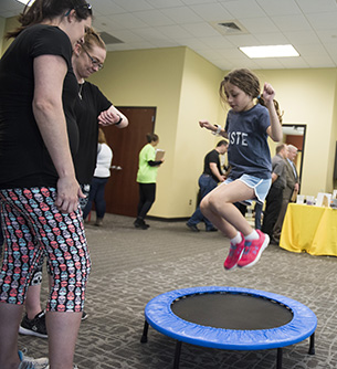 Child jumping on a trampoline at STEM Open House 