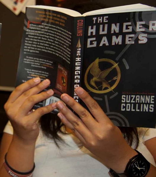 Girl reading the Hunger Games book