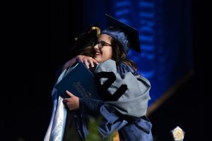 SGA President and Student Commencement Speaker Gabrielle Brown hugs and celebrates with President Spalding as she receives her diploma